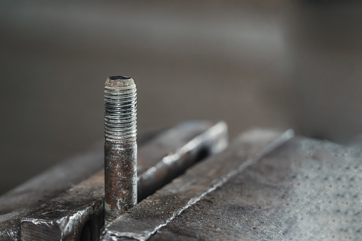 Close-up of a bolt in a metal clip in a garage workshop
