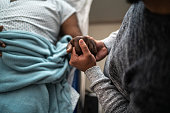 istock Son holding father's hand at the hospital 1341484868