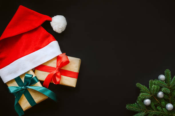 istock Holiday's Background black Santa hat with gifts box, Realistic Looking Christmas Tree Branches with balls 1341485292