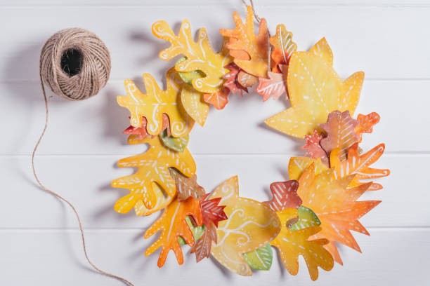 istock Step-by-step tutorial autumn paper wreath. Step 5: wreath is ready. Add ribbon or rope for hanging, top view 1341490083