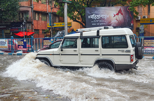 Rashbehari, Kolkata, 09/20/2021: A public car moving through flooded street, caused by overnight monsoon rain which have flooded several parts of city, causing havoc in everyday life. More rains are in forecast across this week.