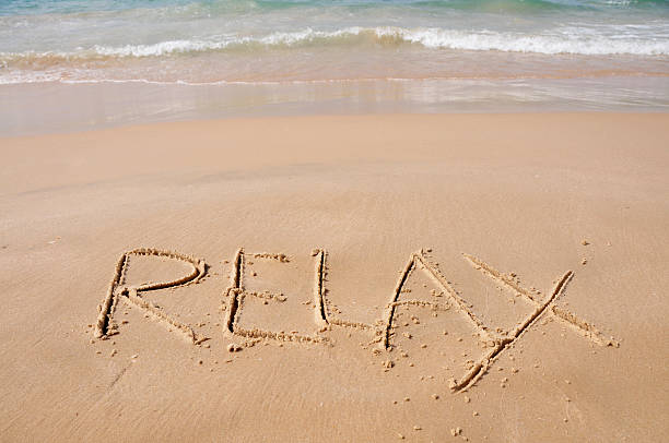 istock Relax spelled out in sand close to the breaking waves 134149365