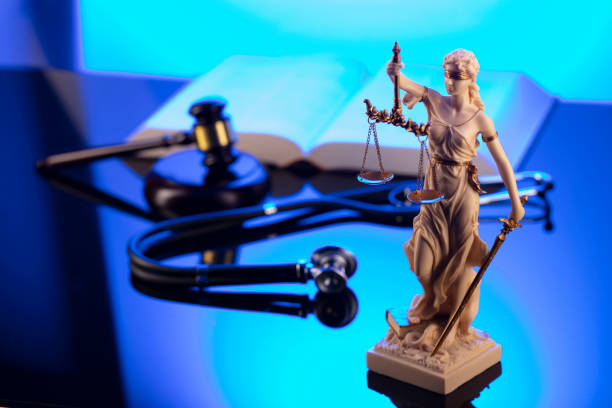 Gavel, Themis, legal code and stethoscope on the glass table. Blue light.