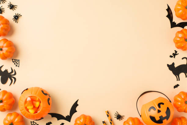 istock Top view photo of halloween decorations pumpkin baskets candy corn straws spiders web bats and black cat silhouettes on isolated beige background with copyspace 1341496858