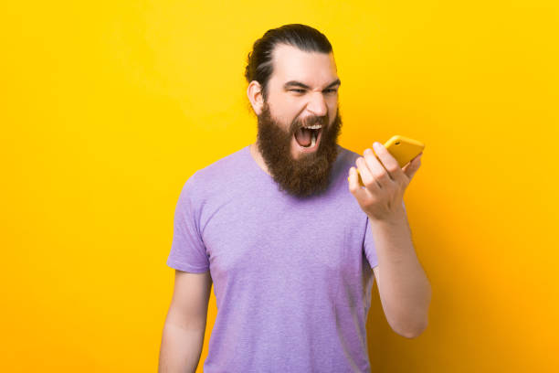 istock Bearded man is yelling at the phone he is holding. 1341501379