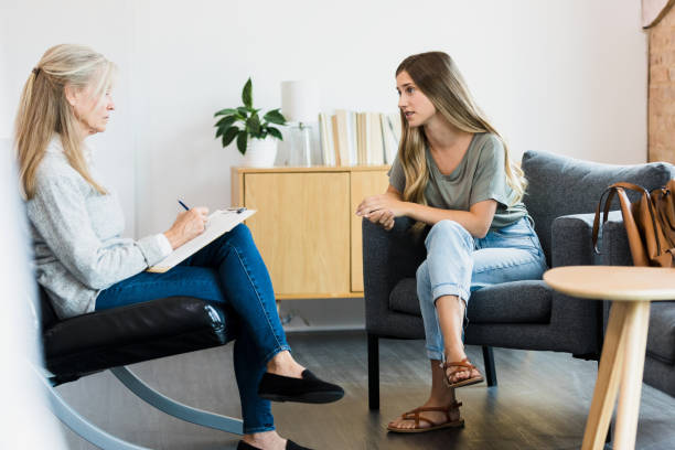 istock Female therapist serious while documenting session with young woman 1341502876