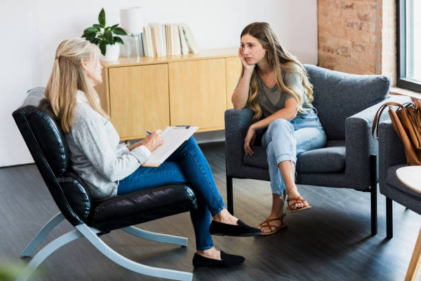 istock Young woman cries as therapist watches with empathy 1341502904