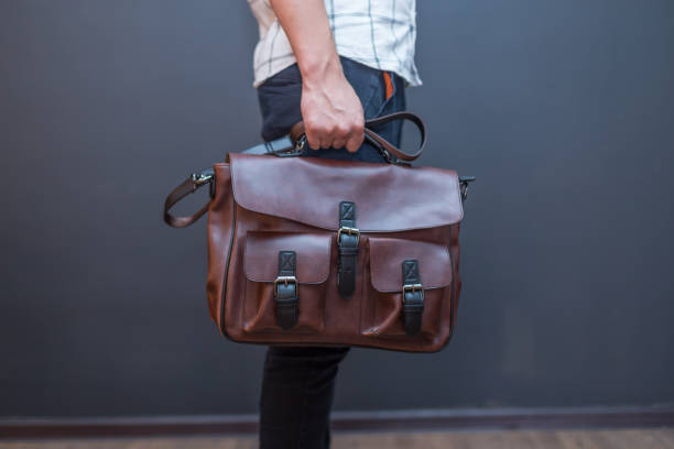 istock Man holding brown leather messenger bag in the hand 1341503560