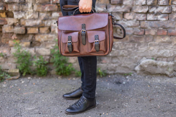 istock Man holding brown leather messenger bag in the hand 1341504762
