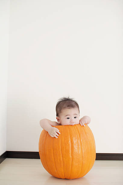 baby in a pumpkin stock photo