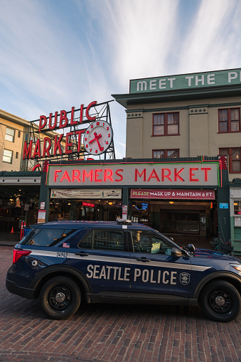 Seattle, USA – Jun 8, 2021: Late in the day the iconic public market sign at Pike Place Market as Seattle Police drive through.