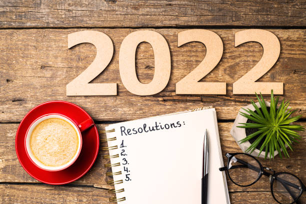istock New year resolutions 2022 on desk. 2022 resolutions with open notebook, coffee cup, eyeglasses on wooden background. Goals, plan, strategy, action, idea concept. New Year 2022 1341506751