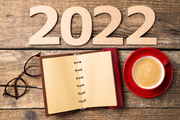 istock New year resolutions 2022 on desk. 2022 resolutions with open notebook, coffee cup, eyeglasses on wooden background. Goals, plan, strategy, action, idea concept. New Year 2022 1341506754