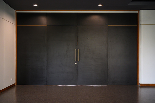 Large black sliding wooden door closed shut. Empty room interior
