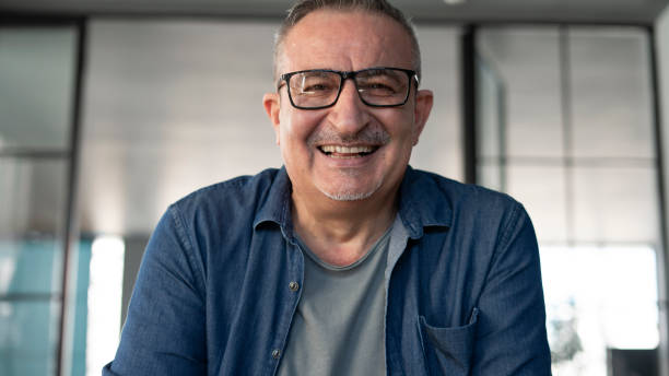 istock Senior man smiling and talking to webcam 1341507255