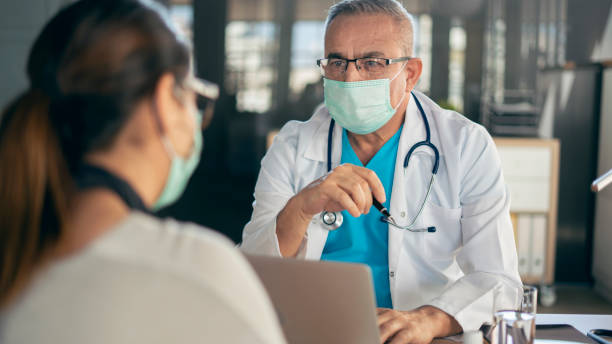 Doctor and patient talking in clinic stock photo