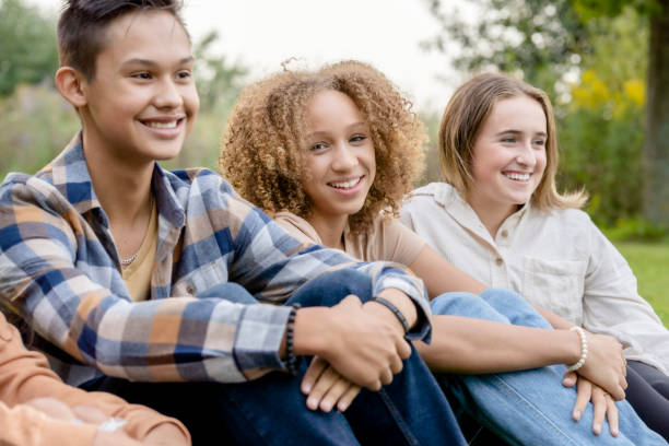 istock Multi-Ethnic High School Students Sitting in a Line Outside 1341510679