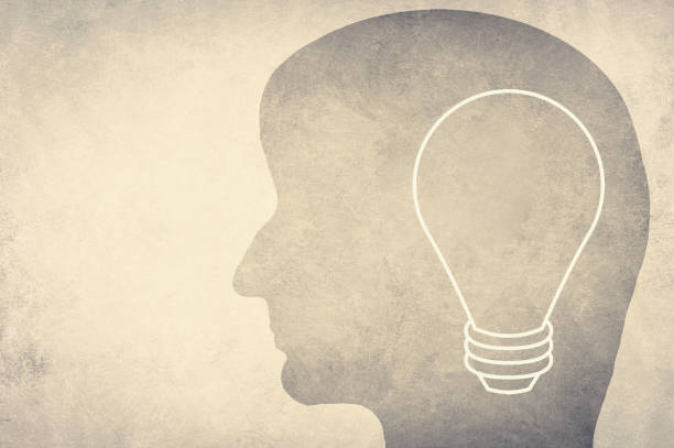 istock Silhouette of a face with a lightbulb, textured background, empty copy space for text 1341512106