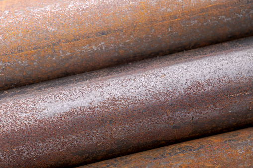 Background of fragments of rusted metal pipes close-up. Industrial abstract background.