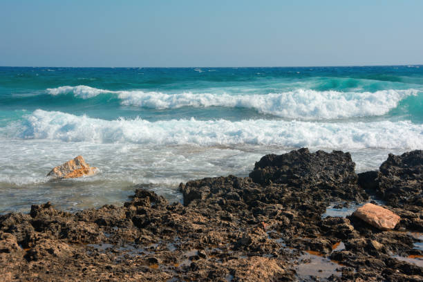istock Powerful large sea waves hitting the rocky shore, on a sunny summer day 1341513643