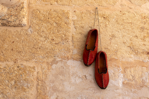 Traditional turkish handmade shoes Yemeni hanging on the wall. Gaziantep, Turkey.