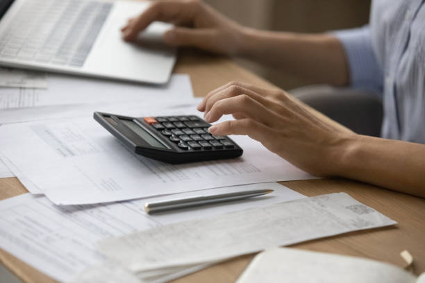 istock Close up woman calculating and paying bills, using laptop 1341515865