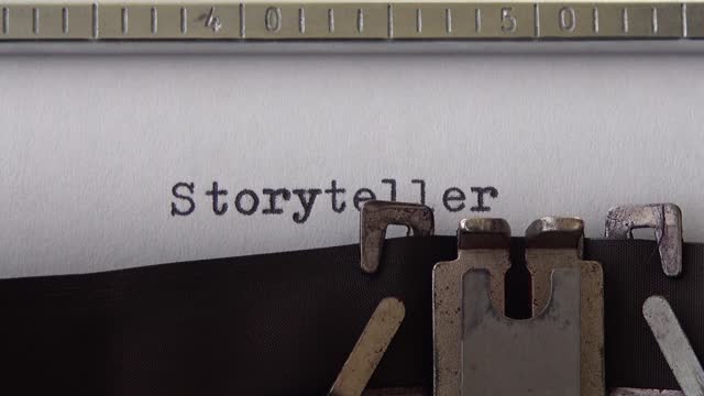 Typing word Storyteller on retro typewriter. Close up.