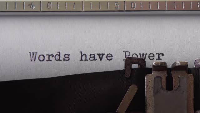 Typing phrase Words have Power on retro typewriter. Close up.