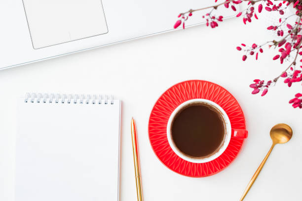 istock Flat lay composition with cup of coffee, branches with red berries and notebook on a white background 1341521652