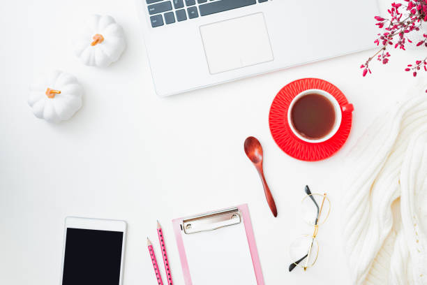 istock Flat lay composition with laptop, cup of coffee, branches with red berries, white sweater on a white background 1341521653