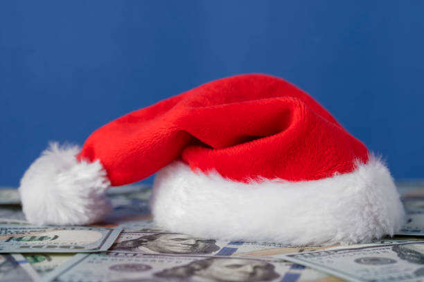 istock Santa hat on heap of US dollars with space for copy 1341521738