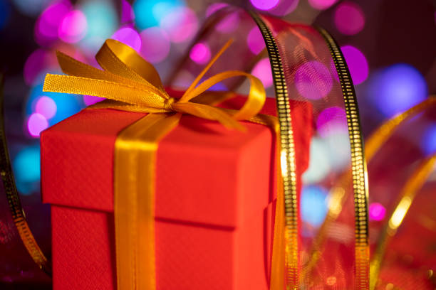 Red gift packages with golden ribbons, among Christmas decoration, on a white background.