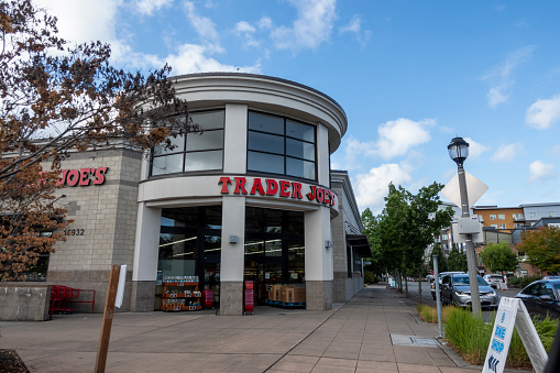 Redmond, WA USA - circa March 2021: Low angle view of a corner entrance to a Trader Joe's grocery store in the downtown area.