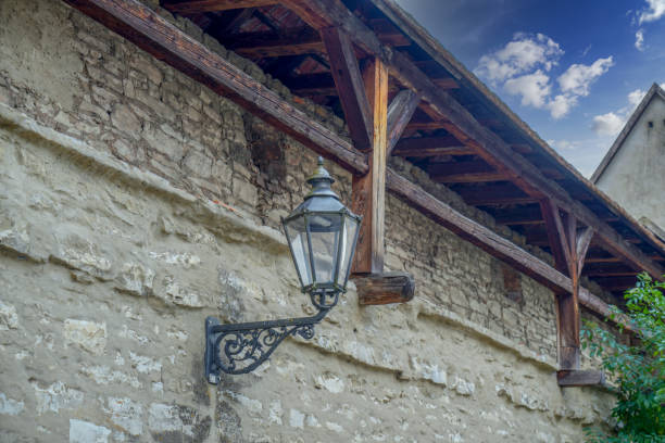 Massive wall with vintage wooden door and street lamp in Salzburg, Austria.