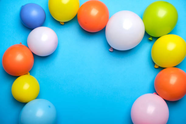istock Colorful balloons on blue table top view 1341530706