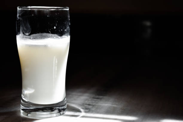 istock Glass of milk on table on black background with copy space 1341533207