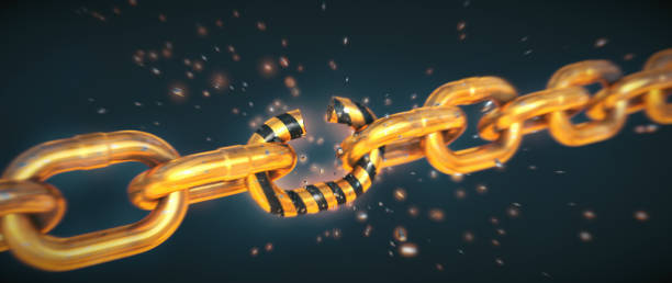 istock Gold-colored chain in the process of dramatically breaking into many scattered pieces, isolated on a dark background. Wide horizontal composition. 1341536614