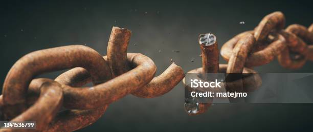 Rusty Old Chain Broken In Two With Focus On The Crumbling Link Isolated On A Dark Defocused Background Wide Horizontal Composition Stock Photo - Download Image Now