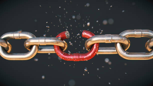 istock Close-up on a shiny chain, with a red link in the process of dramatically breaking into many scattered pieces, isolated on a dark background. 1341536822