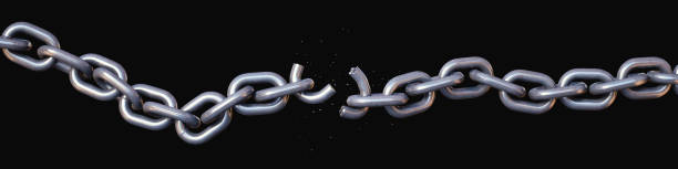 Long shiny chain broken in two, with a crumbling link, isolated on a black background. Wide horizontal composition.