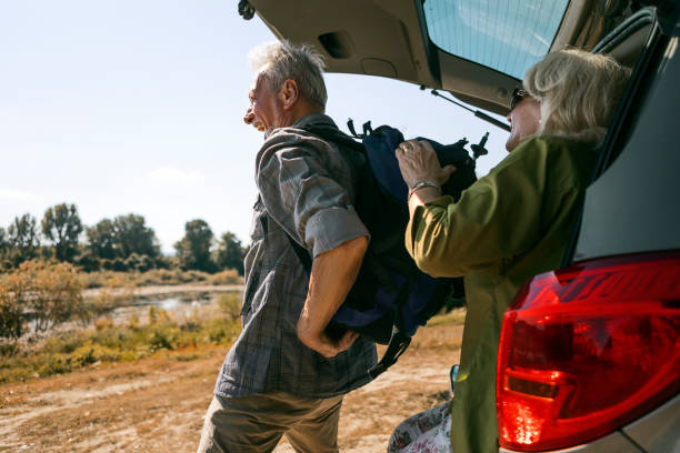 istock Senior man putting backpack on for hiking 1341538369