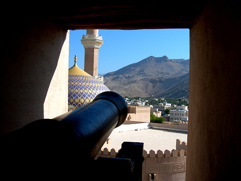 In an Omani fort a cannon was placed in its original and threatening position overlooking a slit in the defensive walls.