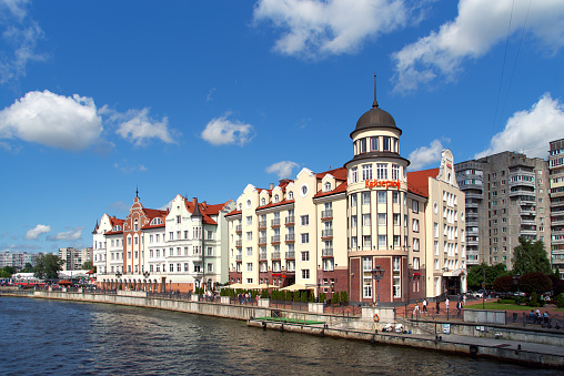 Kaliningrad, Russia - June 13, 2021. Fishing Village on the embankment Pregolya river. Tourist center of the city with pier, walking paths and cafes. Stylized architecture of pre-war Konigsberg  buildings in the German style