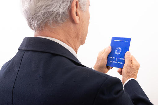 elderly man holding Brazilian social security and work permit.