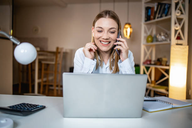 istock Working on laptop and talking on the phone 1341541359