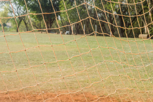 istock texture with football net, daylight, grass, earth in the background. 1341541716