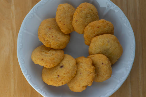 istock Cheddar cheese baked crunchy circle biscuits crisps bites served on white plate on wooden table 1341542998