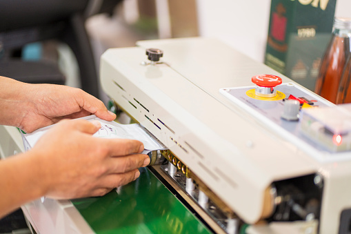 white coffee bag sealing machine is used by one of the employees