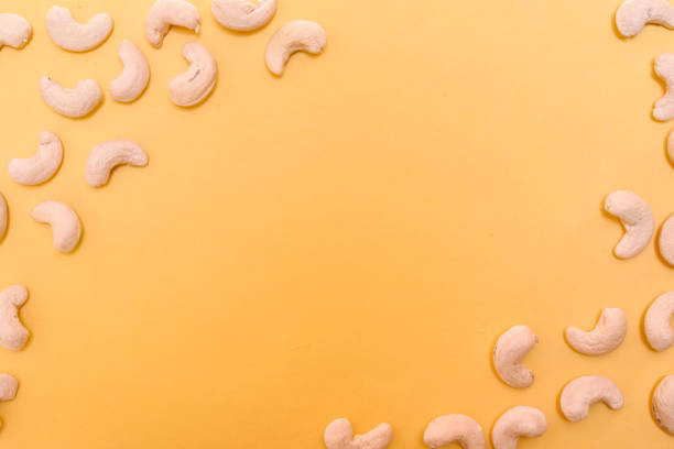 Cashew nuts against the yellow background with space for text