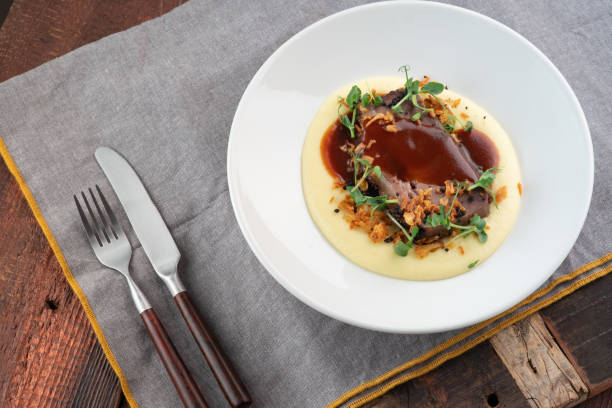 istock Roast beef with mashed potatoes with barbecue sauce on a plate on a wooden background, close up 1341546285